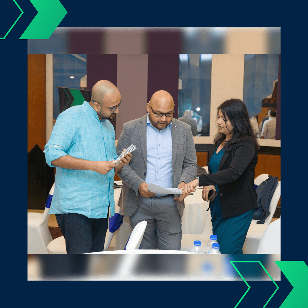 Prashant Bhuyan and other colleagues reviewing event documents and schedules at the Jayesh Logistics Conclave, November 18, 2024.